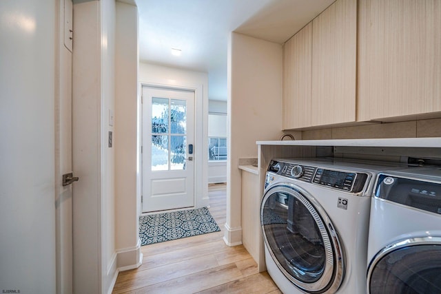 washroom with light wood finished floors, laundry area, and separate washer and dryer