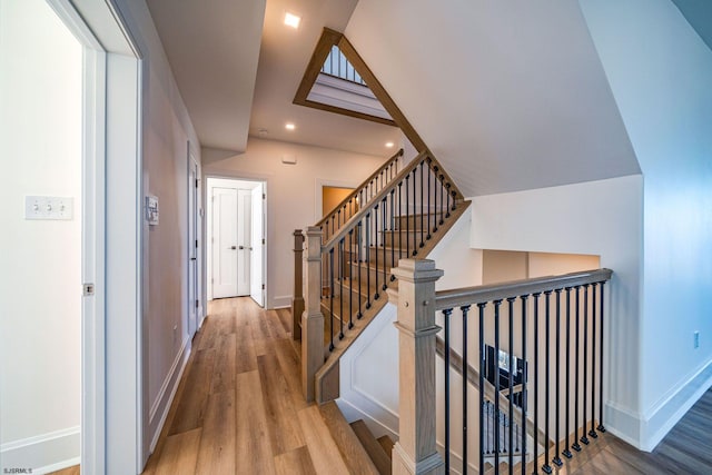 hallway featuring recessed lighting, vaulted ceiling, baseboards, and wood finished floors