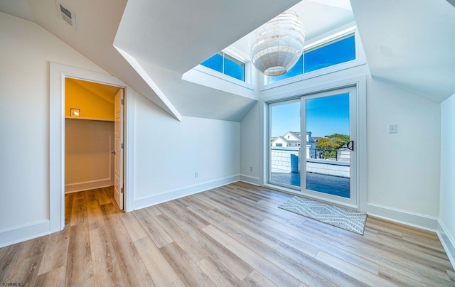 additional living space featuring visible vents, vaulted ceiling, baseboards, and wood finished floors