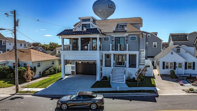 view of front of house with metal roof, a balcony, a garage, concrete driveway, and a standing seam roof