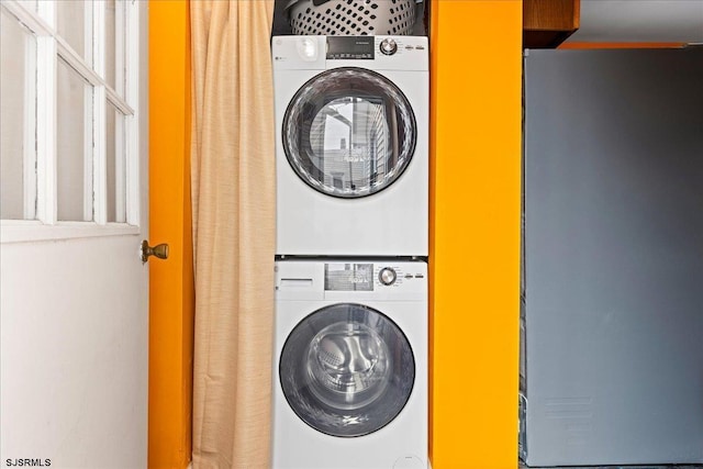 clothes washing area with laundry area and stacked washing maching and dryer