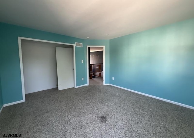 unfurnished bedroom featuring carpet floors, baseboards, visible vents, and a closet