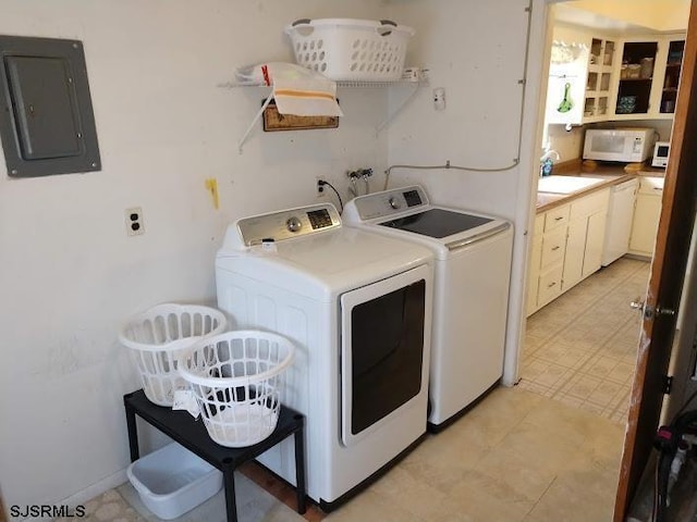 laundry area with laundry area, electric panel, light floors, separate washer and dryer, and a sink