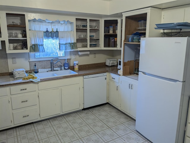 kitchen with light floors, open shelves, white cabinets, a sink, and white appliances