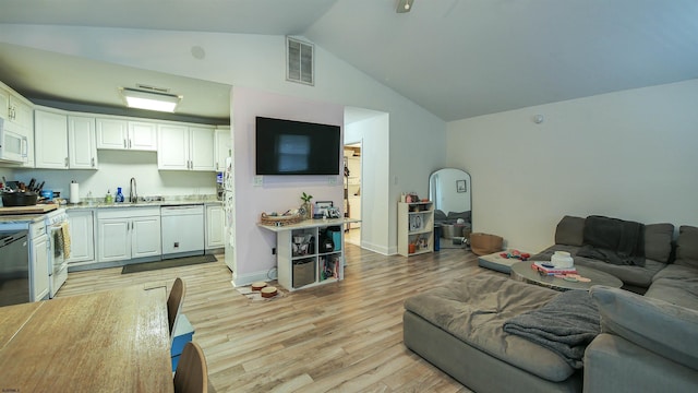 living area featuring vaulted ceiling, baseboards, visible vents, and light wood-style floors