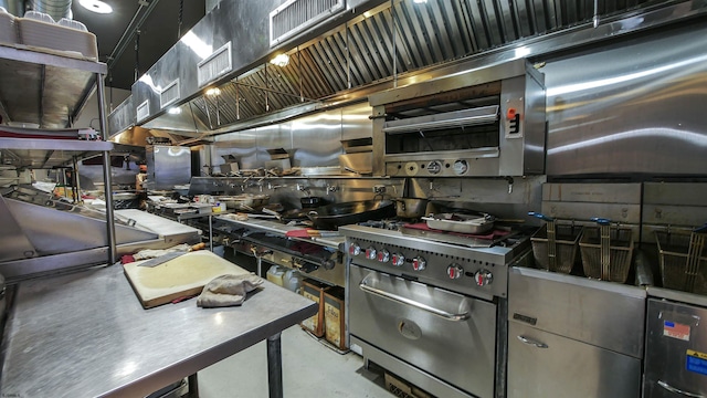 kitchen featuring concrete floors, high end stove, and visible vents