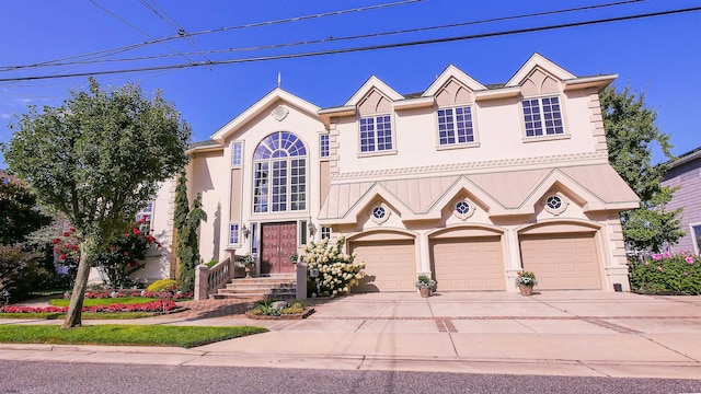 view of front of house with concrete driveway, an attached garage, and stucco siding