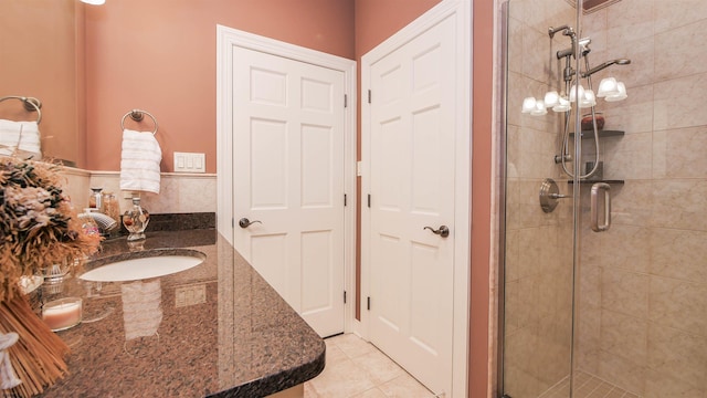 bathroom featuring a stall shower, a sink, and tile patterned floors