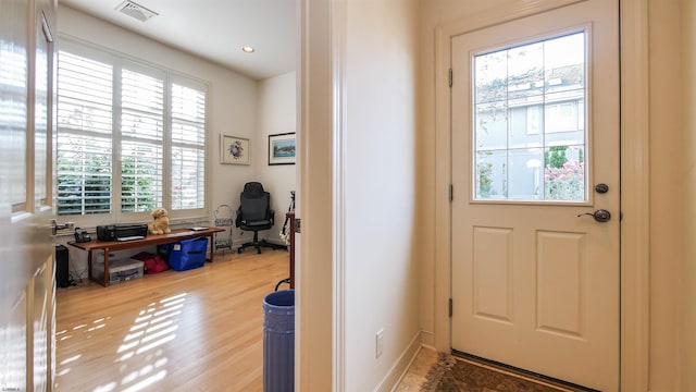 doorway to outside with visible vents, baseboards, and wood finished floors