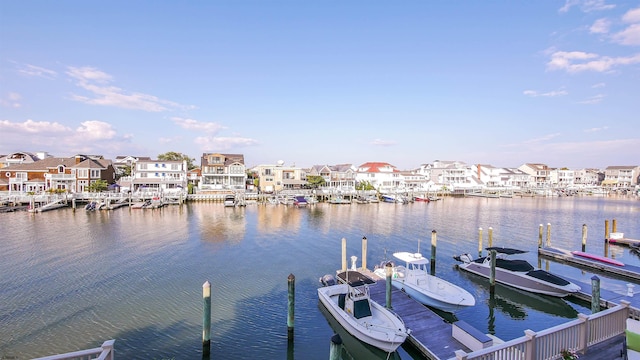 view of dock with a residential view and a water view