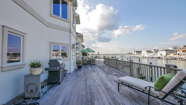 wooden deck with a water view and a grill