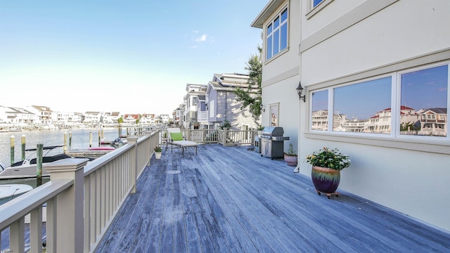 wooden terrace with a residential view, a water view, and grilling area