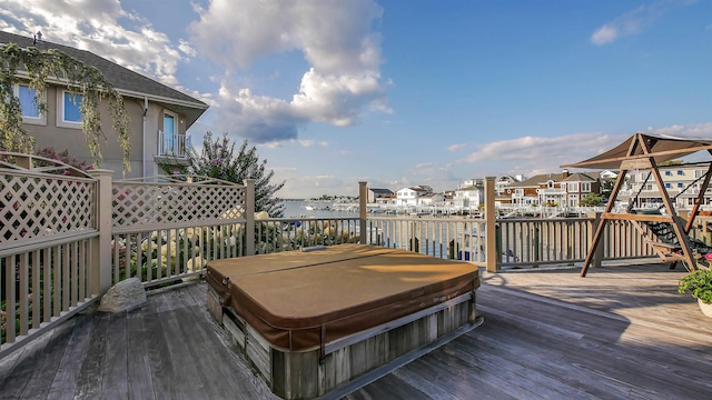 deck featuring a covered hot tub and a residential view