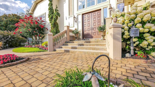 doorway to property featuring stucco siding