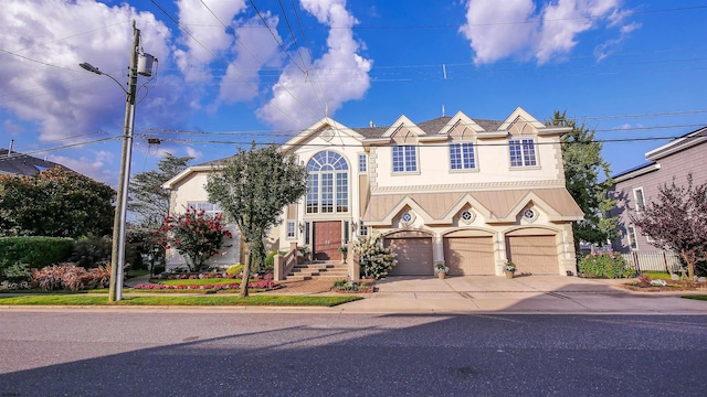 view of front of property with driveway, fence, and stucco siding