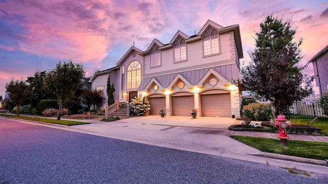 view of front of house with driveway, fence, and stucco siding