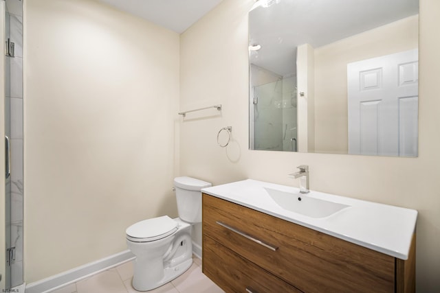 bathroom with toilet, vanity, baseboards, tile patterned floors, and a stall shower