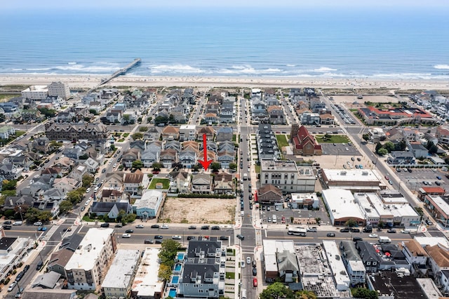 drone / aerial view featuring a water view and a view of the beach