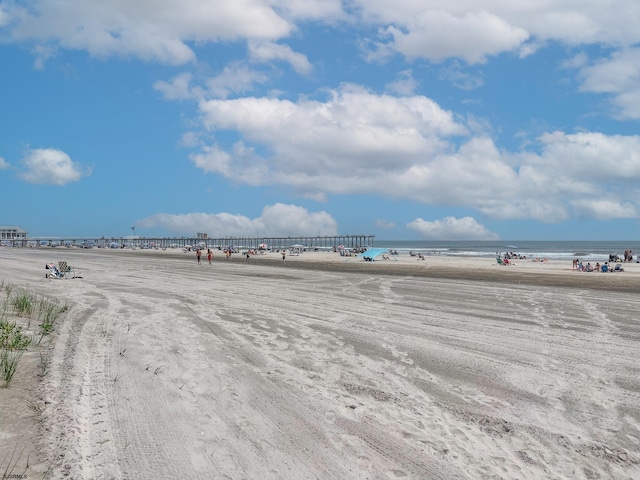 view of property's community featuring a water view and a beach view