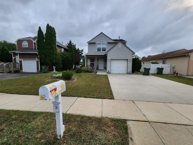 traditional-style house featuring a front yard, concrete driveway, and fence