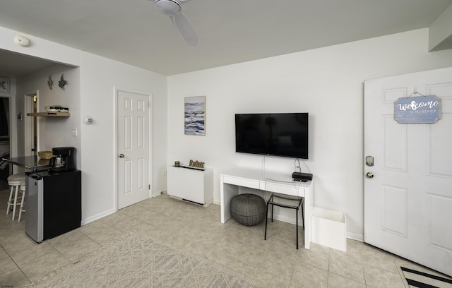 office featuring baseboards, a ceiling fan, and tile patterned floors