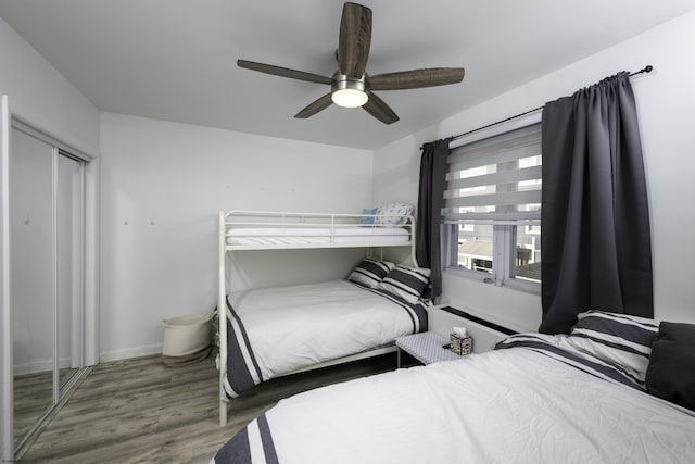 bedroom featuring a closet, ceiling fan, baseboards, and wood finished floors