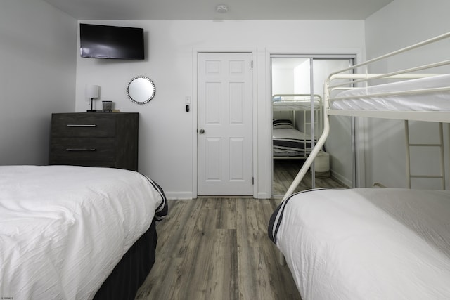 bedroom with a closet, baseboards, and wood finished floors