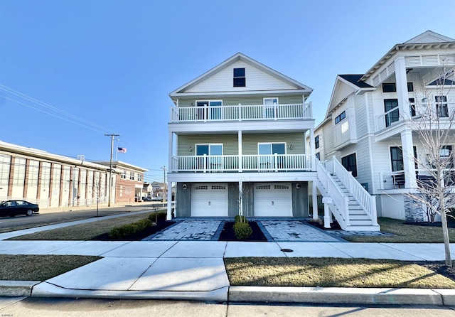 coastal home with driveway, an attached garage, and stairs