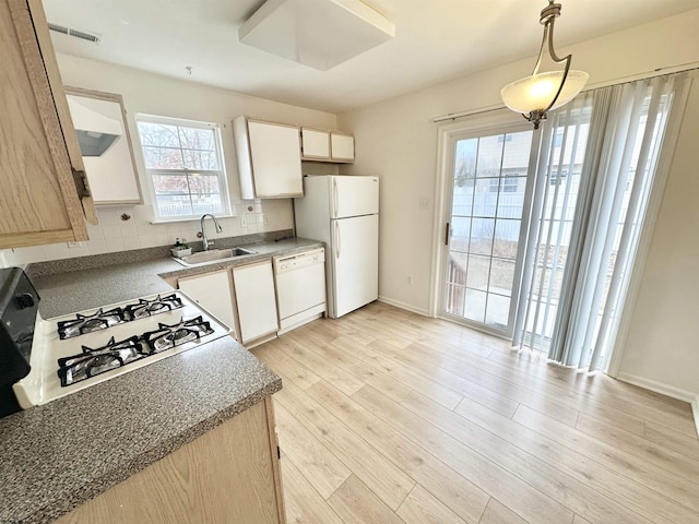 kitchen featuring white appliances, a sink, light wood-type flooring, backsplash, and pendant lighting