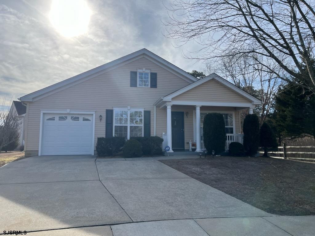 view of front of house featuring a garage, driveway, and a porch