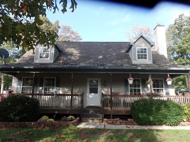 farmhouse with covered porch, roof with shingles, and a chimney