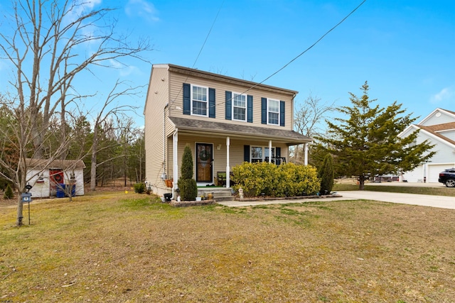 traditional-style home featuring a porch, a front yard, and concrete driveway