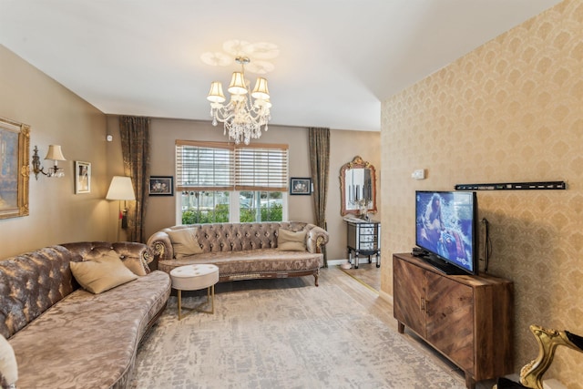 living area featuring wood finished floors, baseboards, an inviting chandelier, and wallpapered walls