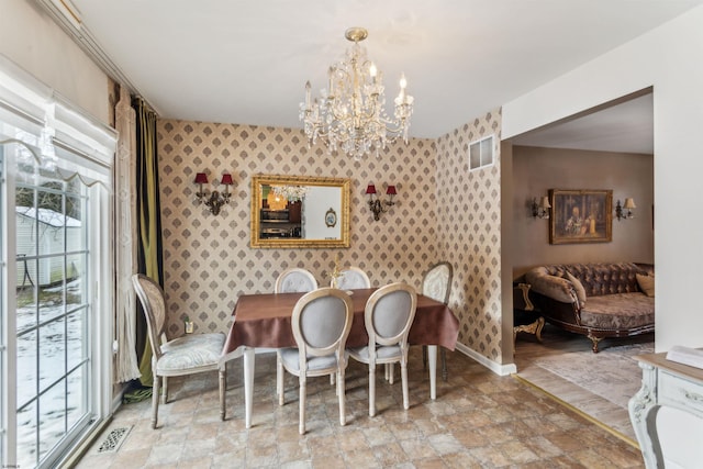 dining area with a notable chandelier, visible vents, stone finish floor, baseboards, and wallpapered walls