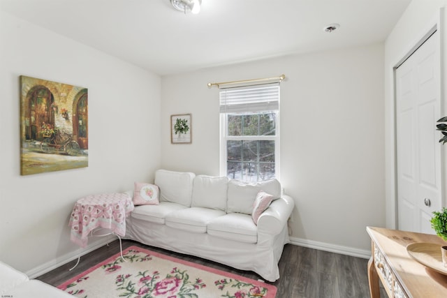 living area with dark wood-style flooring and baseboards