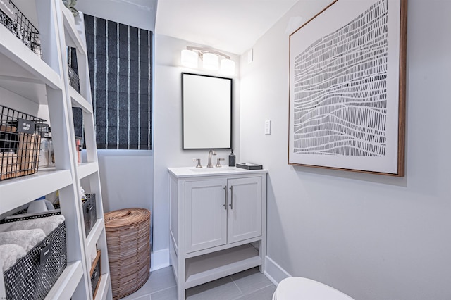 bathroom with baseboards, toilet, vanity, and tile patterned floors