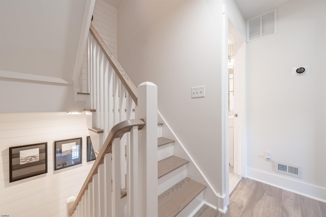 stairs featuring visible vents, baseboards, and wood finished floors