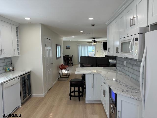 kitchen with beverage cooler, white appliances, white cabinets, light wood-type flooring, and open shelves