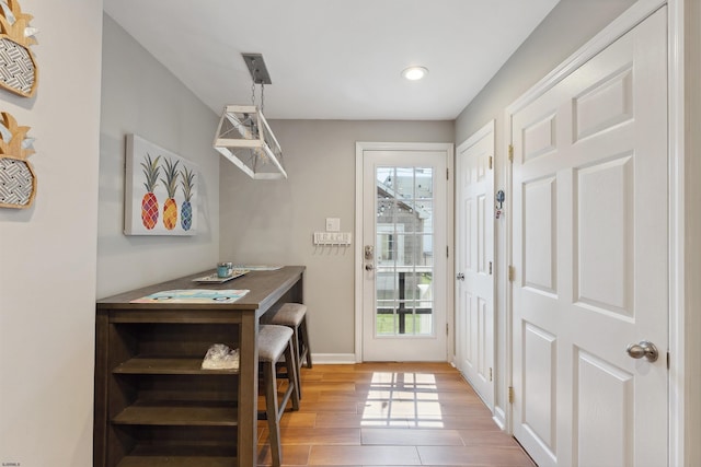 entryway with light wood-style flooring and baseboards