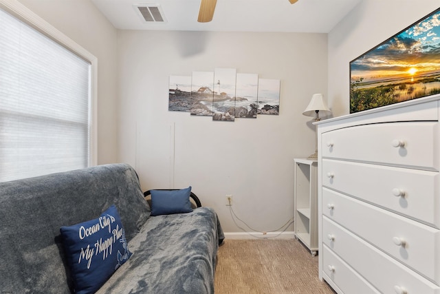 living area featuring a ceiling fan, light colored carpet, visible vents, and baseboards