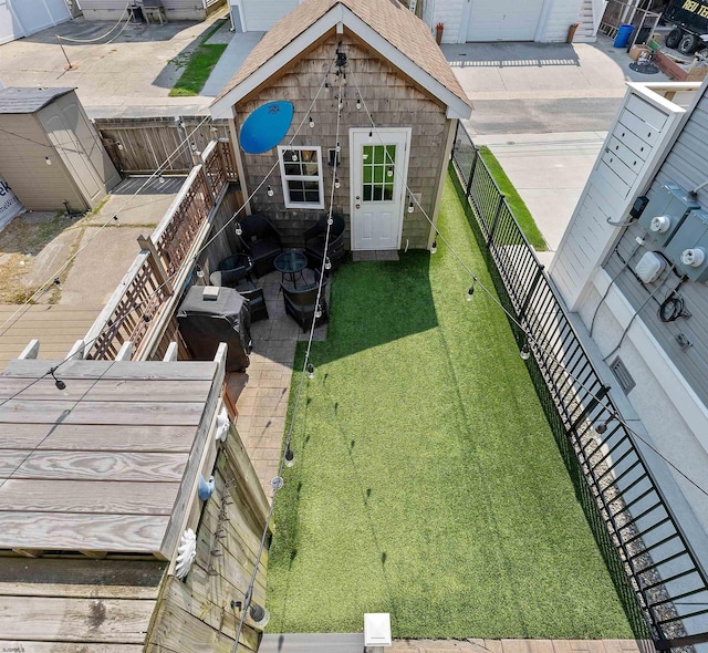 view of yard with a fenced backyard, an outdoor structure, and a storage shed