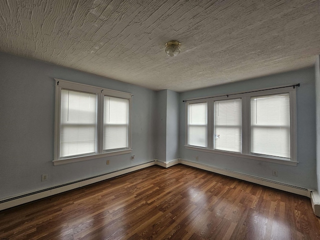 spare room featuring a baseboard heating unit, a textured ceiling, and wood finished floors