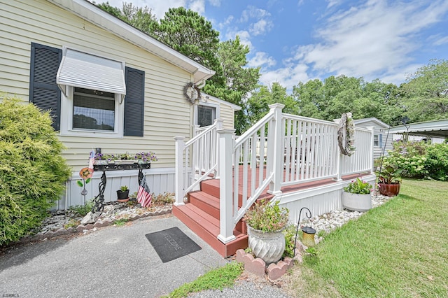 entrance to property with a lawn and a wooden deck