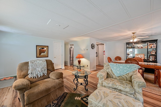 living room featuring a textured ceiling, wood finished floors, and baseboards