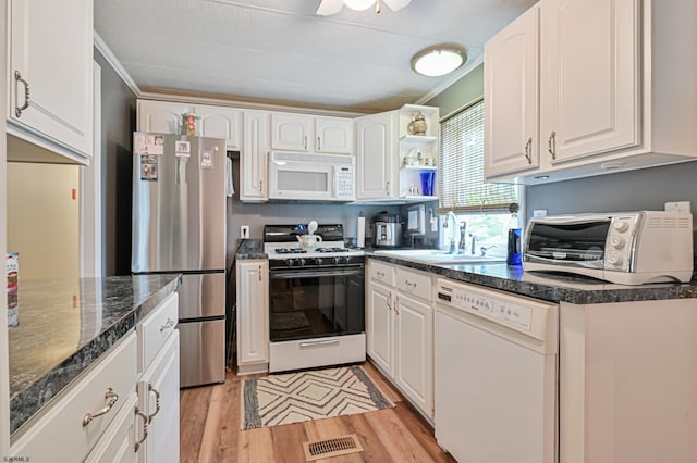 kitchen with white appliances, light wood-type flooring, visible vents, and white cabinets