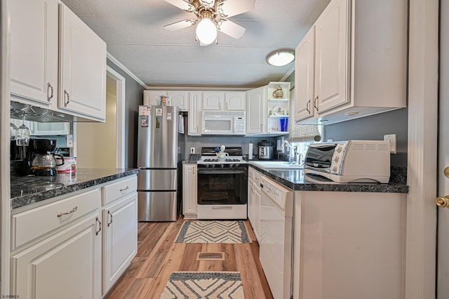 kitchen featuring ceiling fan, white appliances, a sink, white cabinets, and light wood finished floors