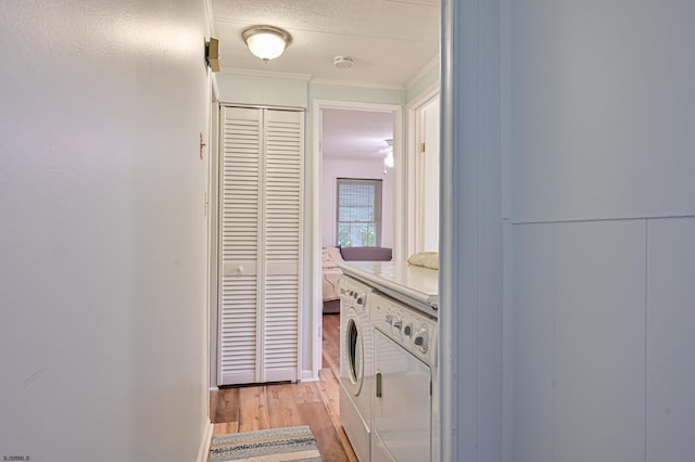 washroom with a textured ceiling, laundry area, crown molding, and light wood-style floors