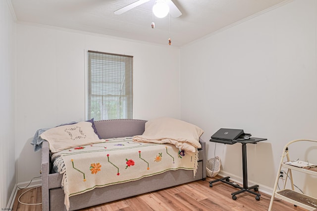 bedroom with ceiling fan, baseboards, crown molding, and wood finished floors