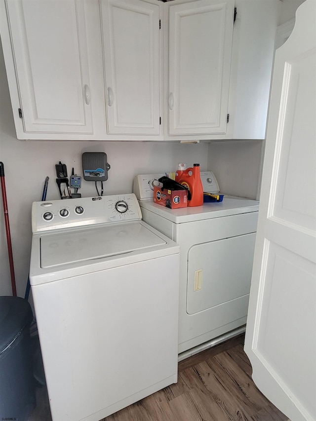 laundry room featuring wood finished floors and separate washer and dryer