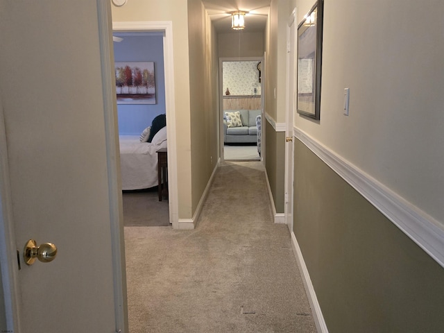 corridor featuring carpet floors and baseboards